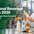 everage specialist reviewing functional drink samples beside a bottling line, illustrating functional beverage trends for 2026.